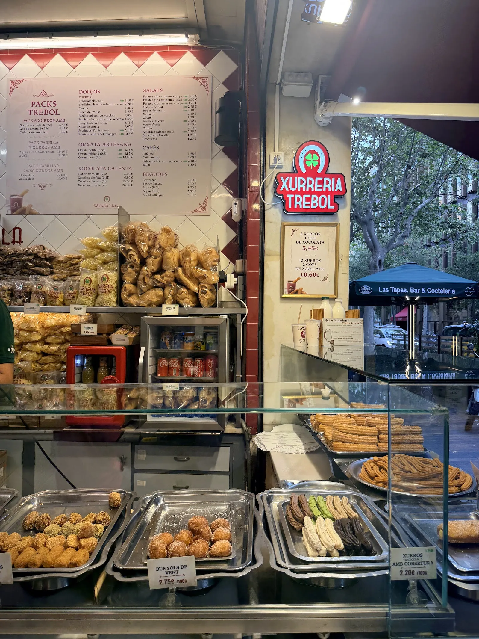 Inside the shop: the display counters and the price board on the tiled wall.