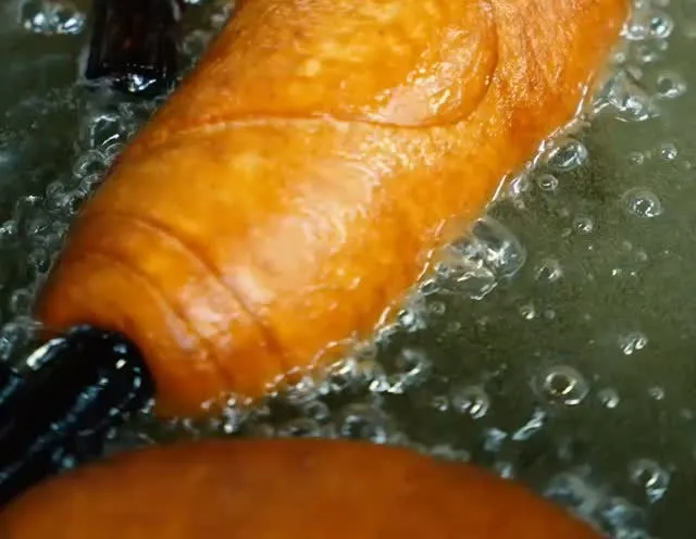A xuixo frying golden in the oil.